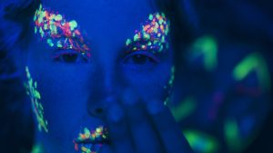 vue rapprochee de femme avec du maquillage fluorescent colore