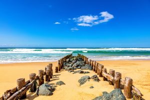 view of wooden pillars and stones on the beach of seignosse, landes, france